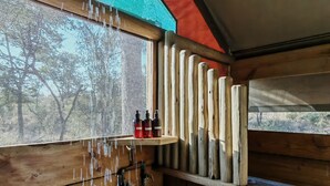 A wooden cabin interior with a window, wooden beams, and a hanging light fixture. - TIMELESS THRILLS: EMBRACE THE ESSENCE OF A CONSERVATION-DRIVEN EXPERIENCE (Phalaborwa)