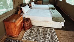 A spacious tented room with two beds, a wooden dresser, and a woven rug. - TIMELESS THRILLS: EMBRACE THE ESSENCE OF A CONSERVATION-DRIVEN EXPERIENCE (Phalaborwa)