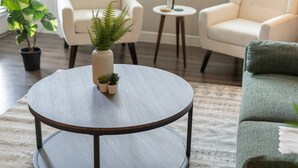 A round wooden table with a white vase and small plants. - Charming Tempe 1BR Designer Furnishings, Patio & Gym (Tempe)