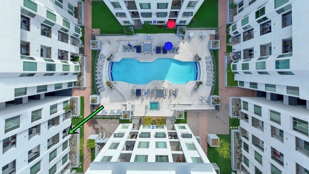 A high-rise building with a central swimming pool, multiple balconies, and a green lawn area. - Charming Tempe 1BR Designer Furnishings, Patio & Gym (Tempe)