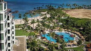 A resort with a swimming pool, beach, and ocean view.