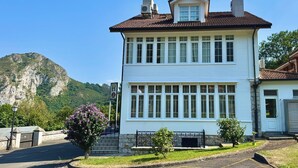 A two-story building with a white facade, multiple windows, and a red-tiled roof. - Hotel Quinta Solera (Oviedo)
