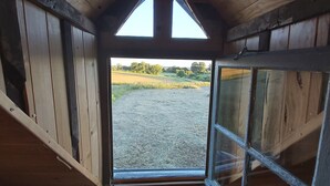 A wooden barn with a large open door leading to a gravel driveway. - Small, quiet country house, 100% nature, no neighbors or noise (Tinchebray-Bocage)