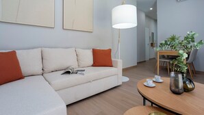 Una sala moderna con un sofá, una mesa de centro y un comedor con sillas y una mesa.