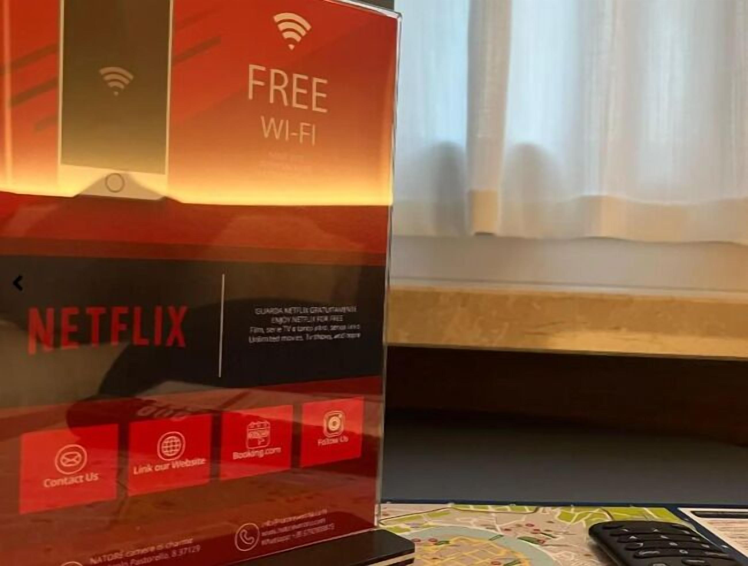 A promotional display for free Wi-Fi and Netflix services, with a remote control and a map on the table.
