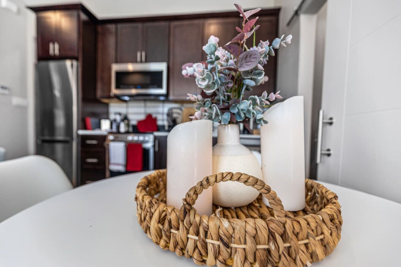 A kitchen with dark wooden cabinets, a stainless steel refrigerator, a microwave, and a stove.