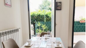 Een eettafel gedekt met witte kopjes, glazen en een mand met brood.