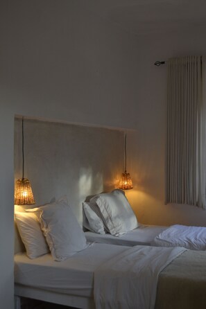 A bedroom with a bed, pillows, and two hanging lamps. - Villa Quince  (Ouirgane)