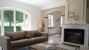 A living room with a beige sofa, a patterned coffee table, and a fireplace. - Villa air-conditioning heated swimming pool Alpilles view Mouries (Mouriès)