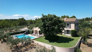 A two-story house with a swimming pool, surrounded by trees and a well-maintained lawn. - Villa air-conditioning heated swimming pool Alpilles view Mouries (Mouriès)