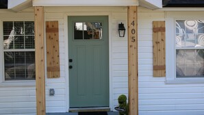 A house with a green door, wooden shutters, and the number 405 on the wall. - Delightful 2-bedroom house with AC in charming Easley (Easley)