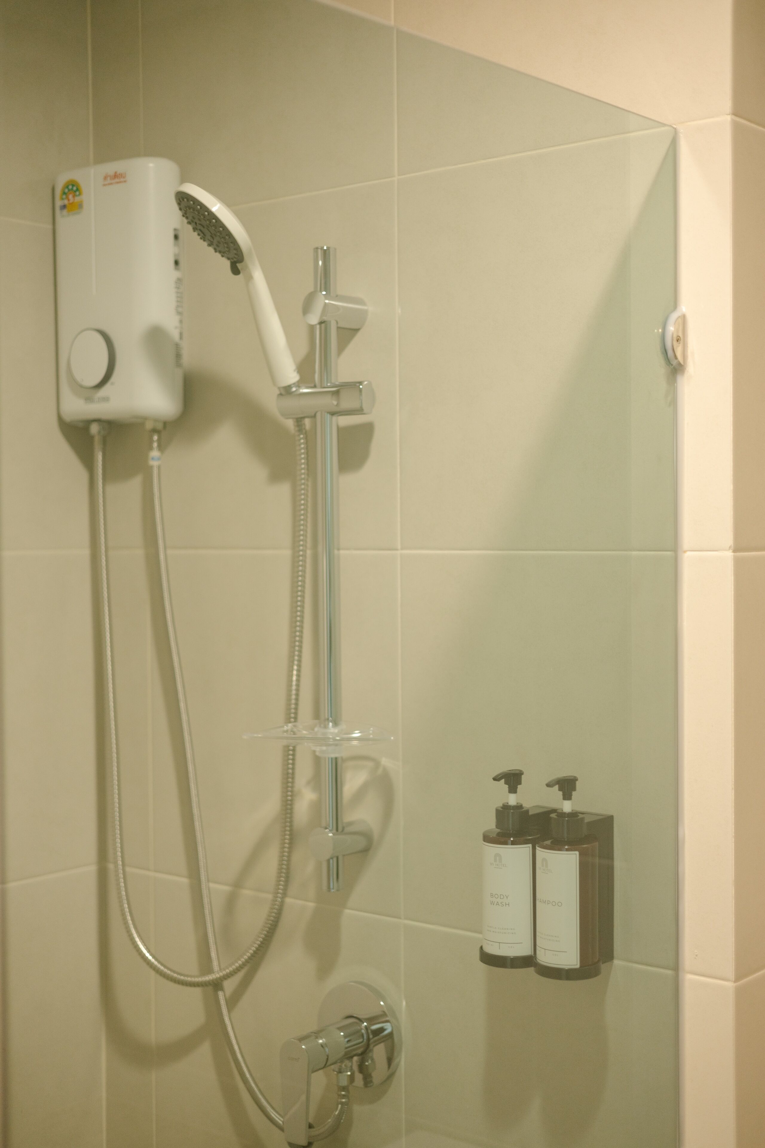 A shower with a handheld showerhead and a wall-mounted control panel.