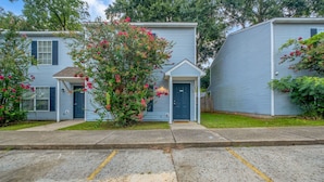 A row of two-story townhouses with a small front porch and a garage.