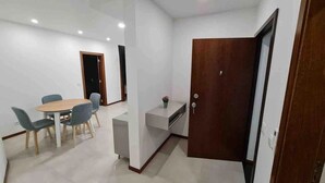 A compact living space with a dining area, kitchenette, and a door. - Up Sal Business (Aveiro)