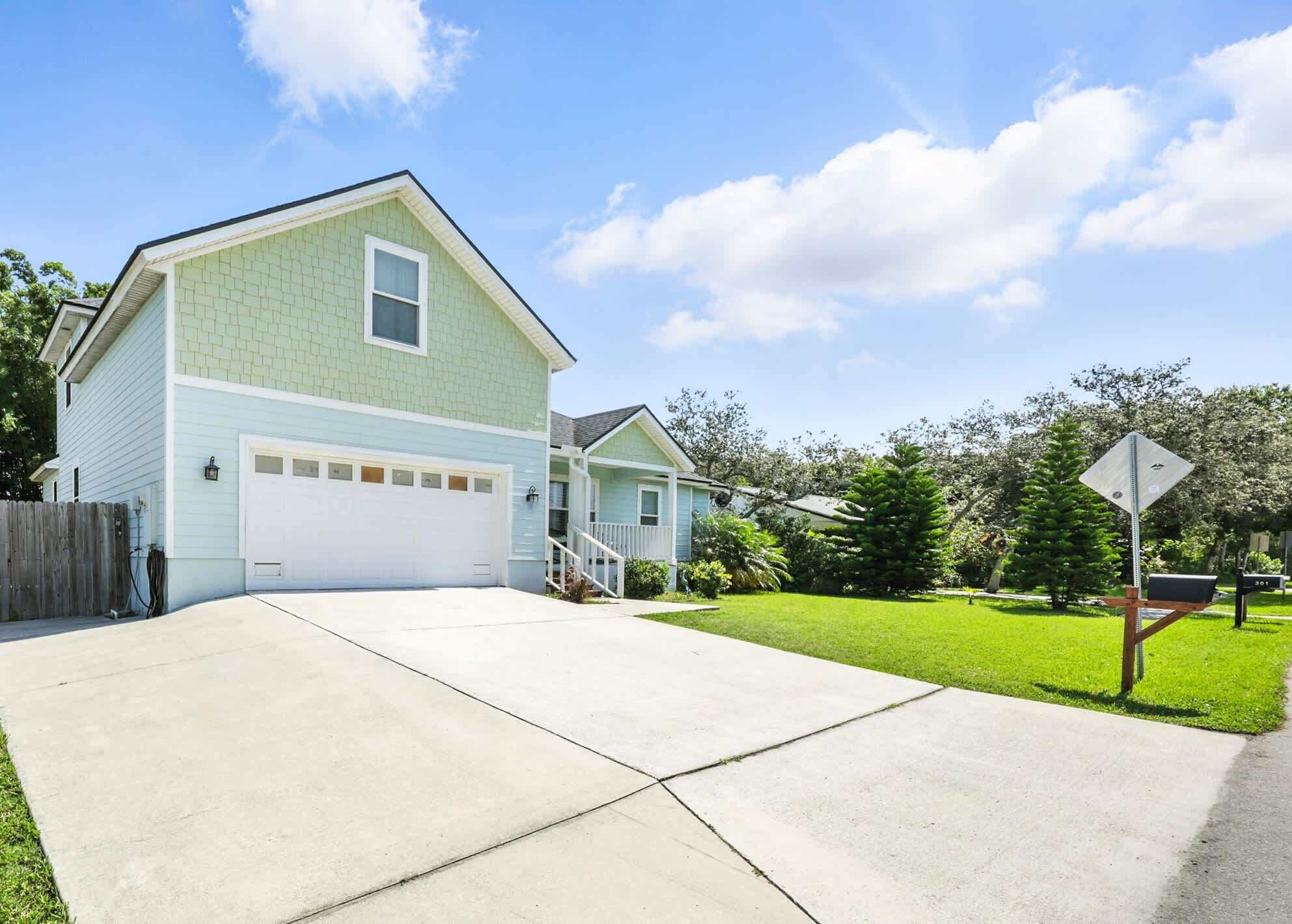 A two-story house with a garage, a well-maintained lawn, and a mailbox.