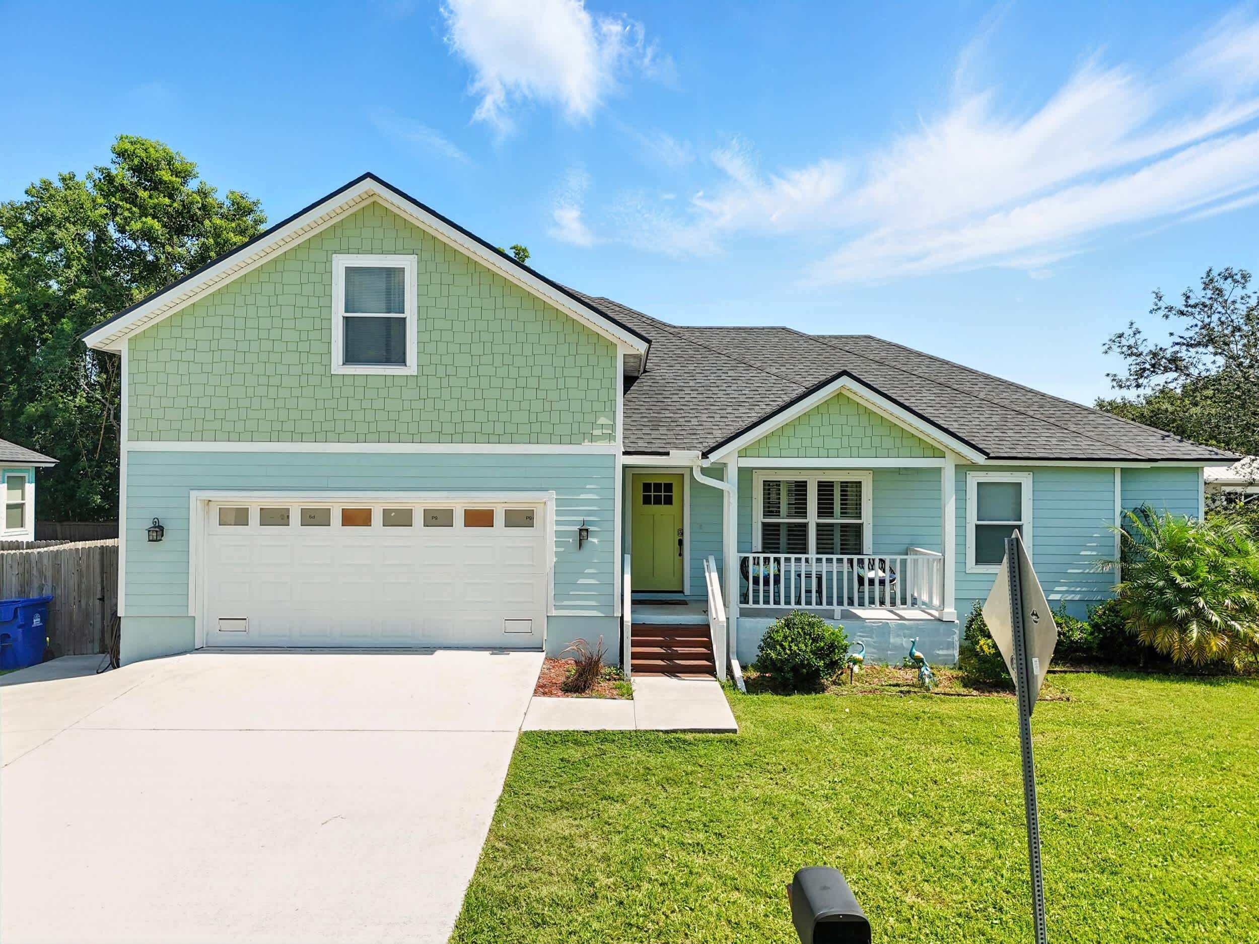 A two-story house with a garage, a front porch, and a small front yard.