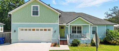 A two-story house with a garage, a front porch, and a small front yard.