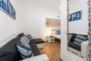 Un soggiorno moderno con un divano, un tavolino e uno specchio decorativo.