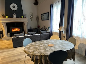Un salon avec une cheminée, une table ronde et un canapé.