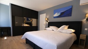 Un dormitorio con cama, escritorio y espejo.