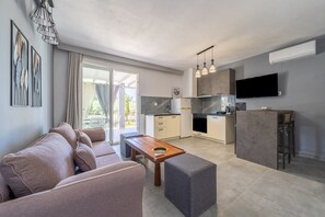 A modern apartment with a living room, kitchenette, and a balcony.