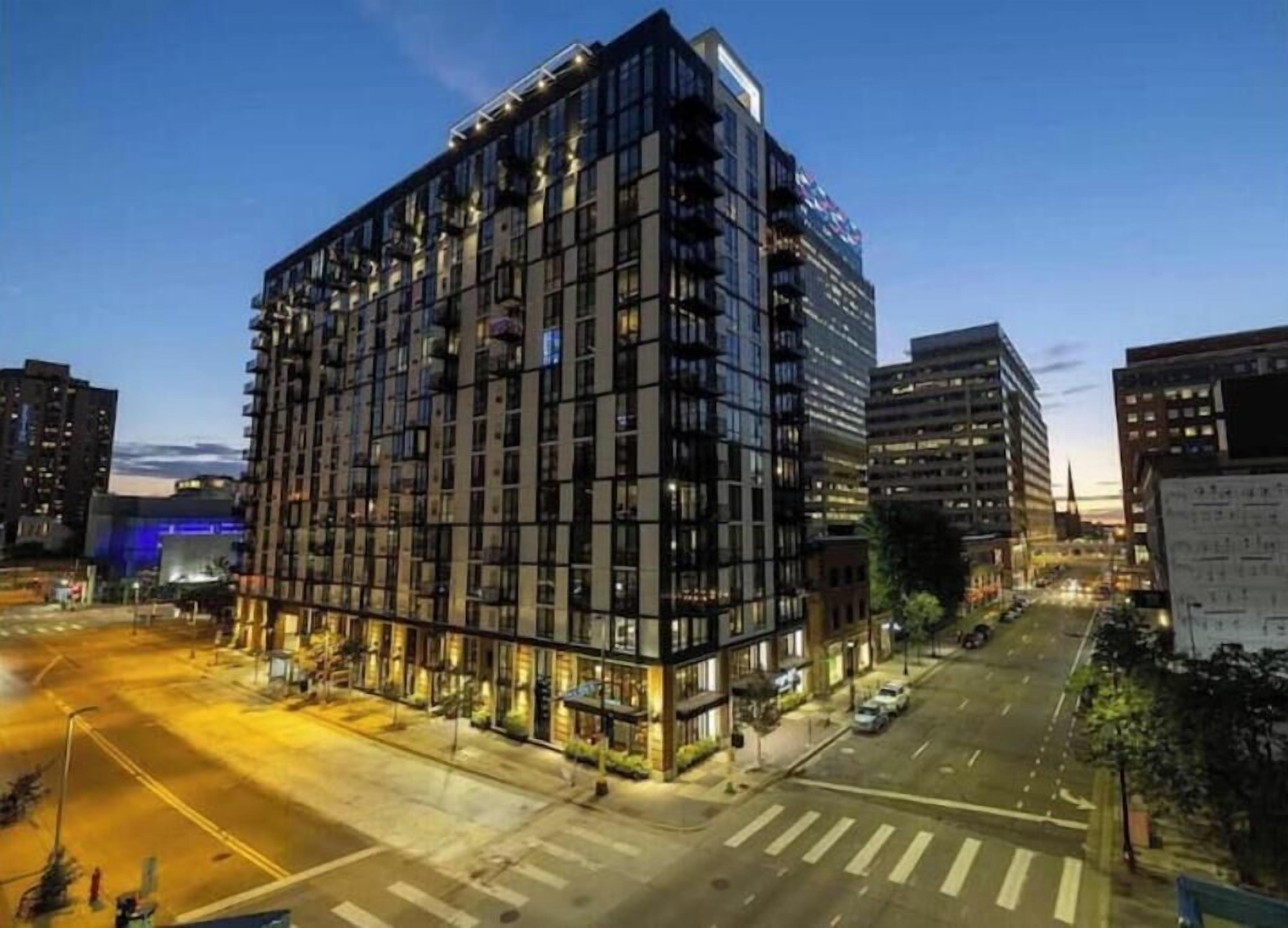 A multi-story hotel with a modern design, featuring a large glass facade and multiple balconies.