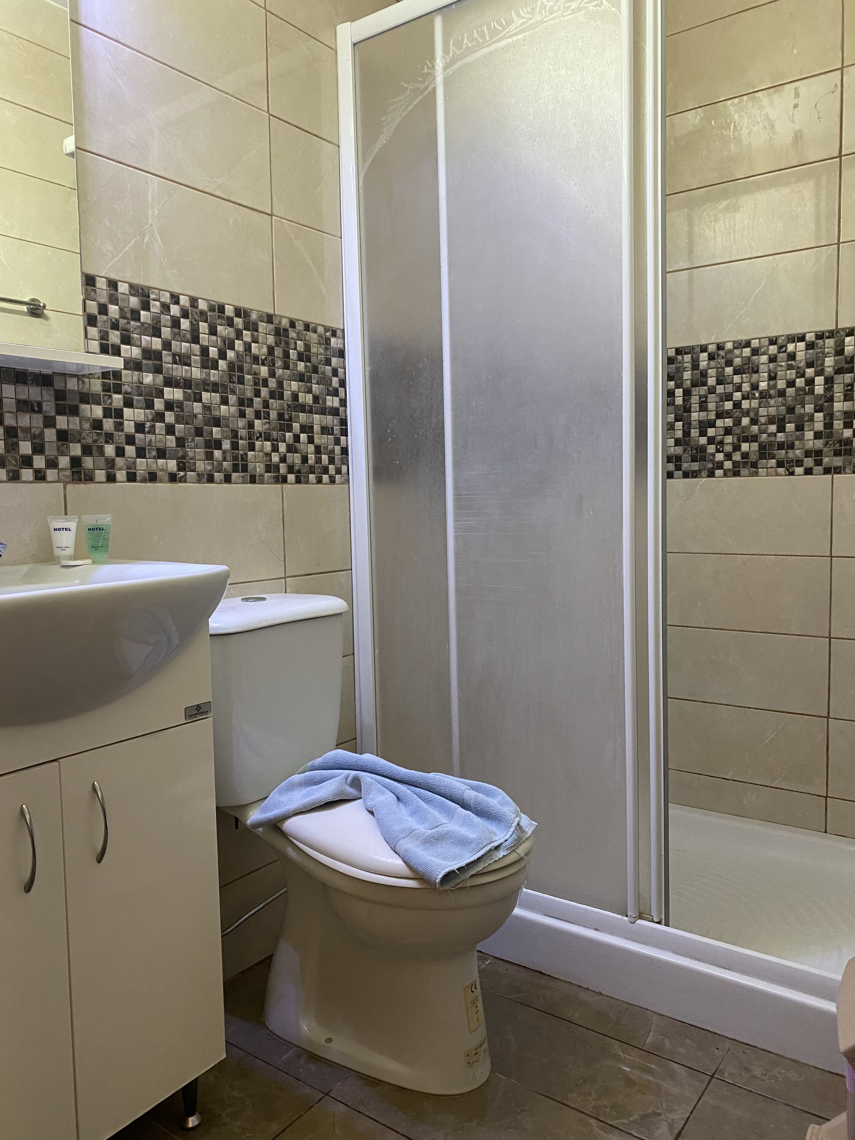 Un baño con inodoro, lavamanos y cabina de ducha.