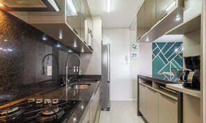 A modern kitchen with a gas stove, stainless steel refrigerator, and a built-in oven.