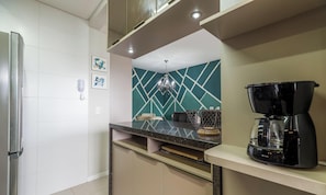 A modern kitchen with a built-in coffee maker, a microwave, and a refrigerator. - Apt With Barbecue Near the Beach Rgn0203 (Florianópolis)