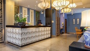 A reception area with a modern design, featuring a reception desk, decorative lighting, and traditional Asian art pieces. - Room-hotel With Balcony in Phukettown (Phuket)