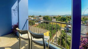 A balcony with two chairs, a view of a cityscape, and a clear blue sky. - Room-hotel With Balcony in Phukettown (Phuket)