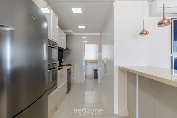 A modern kitchen with stainless steel appliances, a dishwasher, and a countertop with a sink. - Apartment w/ Barbecue 160m From the Beach Rgl0304 (Florianópolis)