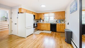 Une cuisine moderne avec des meubles en bois, un réfrigérateur blanc et un lave-vaisselle.