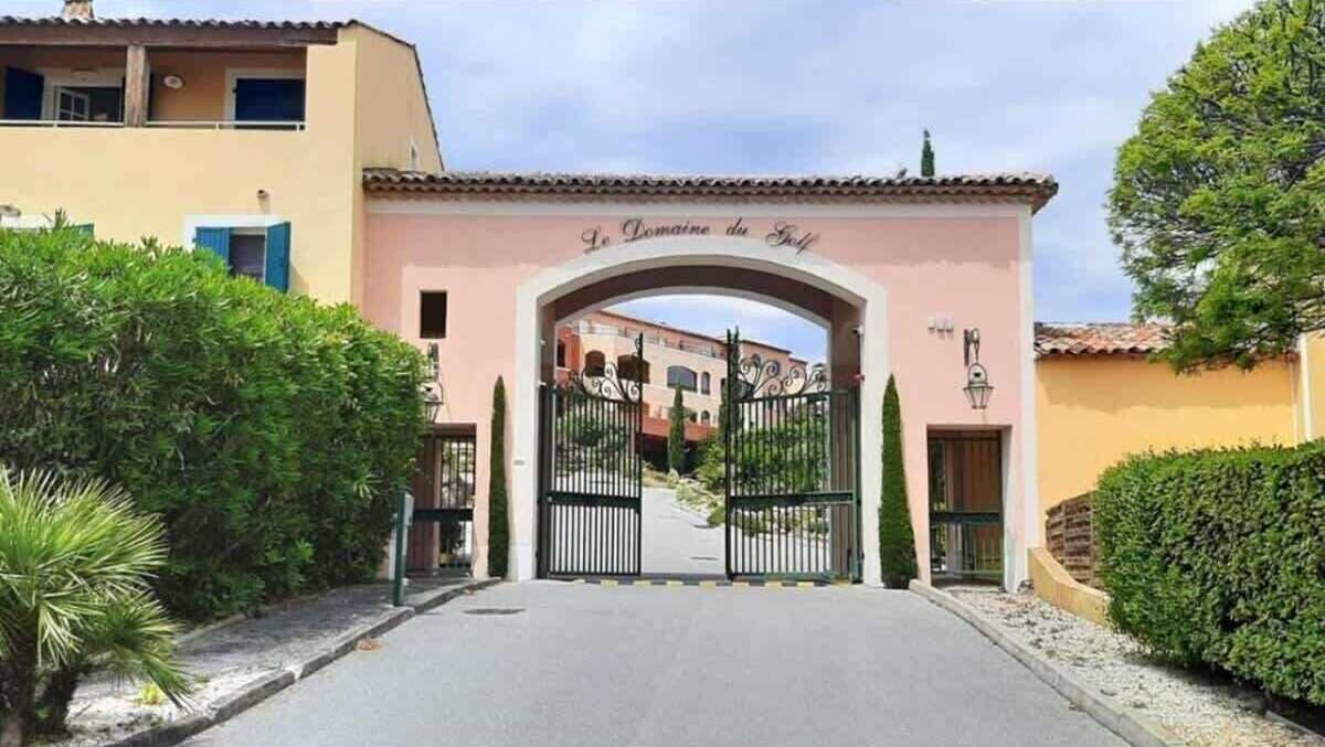 Una entrada cerrada a una propiedad llamada "Le Domaine du Soleil", con un camino despejado que lleva a la puerta.
