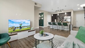 A modern living room with a flat-screen TV, a coffee table, and a sofa. - Cozy Green 1BR Retreat Pool, Hot Tub & Near ASU & Mill Ave (Tempe)
