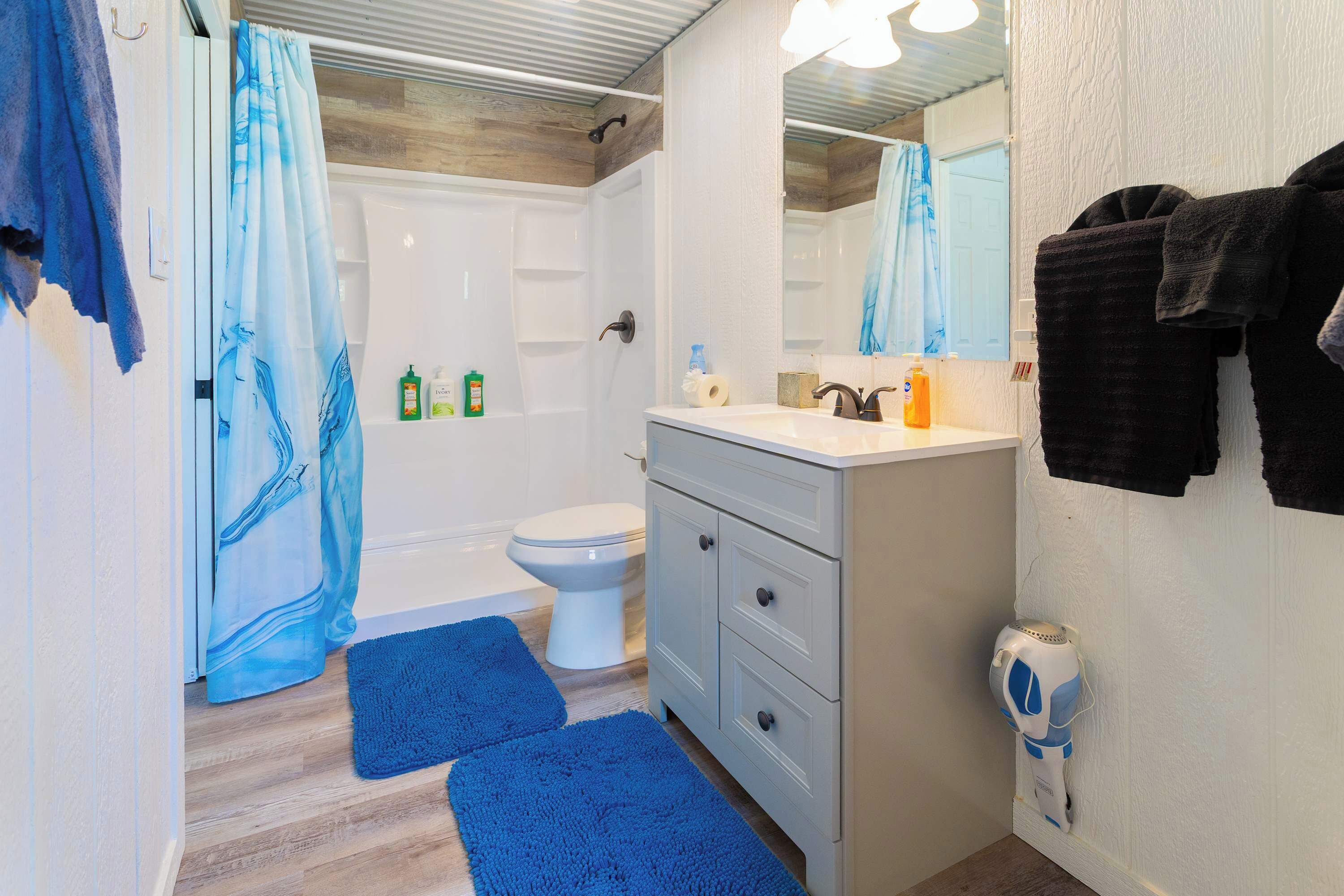 Un baño con ducha, inodoro y tocador.