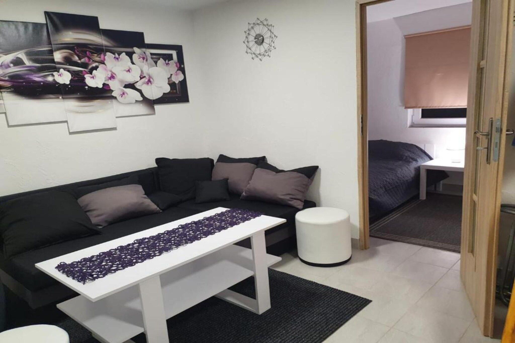 A modern living room with a sofa, a coffee table, and a small white stool.