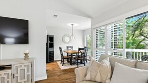 A living room with a TV, a dining table, and a sofa. - Lighthouse Tennis Villas: Walk to both Harbor Town, Shops at Sea Pines STR077622 (Hilton Head)