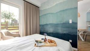 Une chambre d’hôtel avec un lit, un plateau de petit-déjeuner, une fenêtre avec des rideaux et une vue sur l’extérieur.