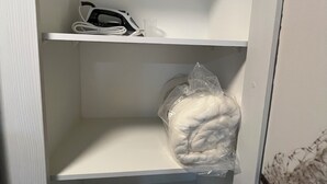 A white shelving unit with a hairdryer, a plastic bag, and a white container. - M&C DC 108 (Santiago)
