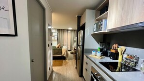 A modern kitchen with a built-in oven, a coffee maker, and a sink. - M&C DC 108 (Santiago)