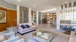 A modern living room with a sofa, armchairs, a coffee table, and a dining area with a table and chairs. - Duplex House w/ Pool, 850m From the Beach Rdt0124 (Florianópolis)
