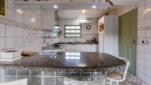 A kitchen with a granite countertop, white cabinets, and a green door. - Pleasant Townhouse w/ BBQ 90m From the Sea Rdd657 (Florianópolis)