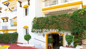 A hotel entrance with a sign reading "Pass the Keys" and a red carpet leading to the door.
