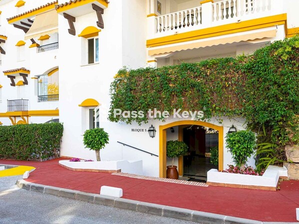 A hotel entrance with a sign reading "Pass the Keys" and a red carpet leading to the door.