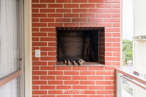 Un mur en briques avec un barbecue intégré et une prise de courant.