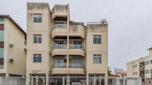 A multi-story residential building with balconies and a gated entrance.