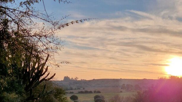 A rustic wooden cabin in a grassy field with a sunset in the background. - Brand new! Charming corner in the sierras (Marmarajá)