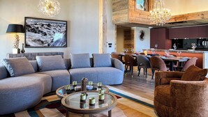 A modern living room with a sectional sofa, a round coffee table, and a dining area with chairs and a table. - New Agora 202 Duplex | Central close to the slopes (Les Gets)