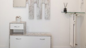 Une salle de bain minimaliste avec un meuble-lavabo en bois, un miroir et une étagère en verre.
